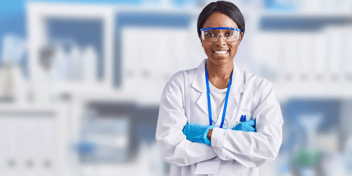 woman smiles facing camera in lab attire
