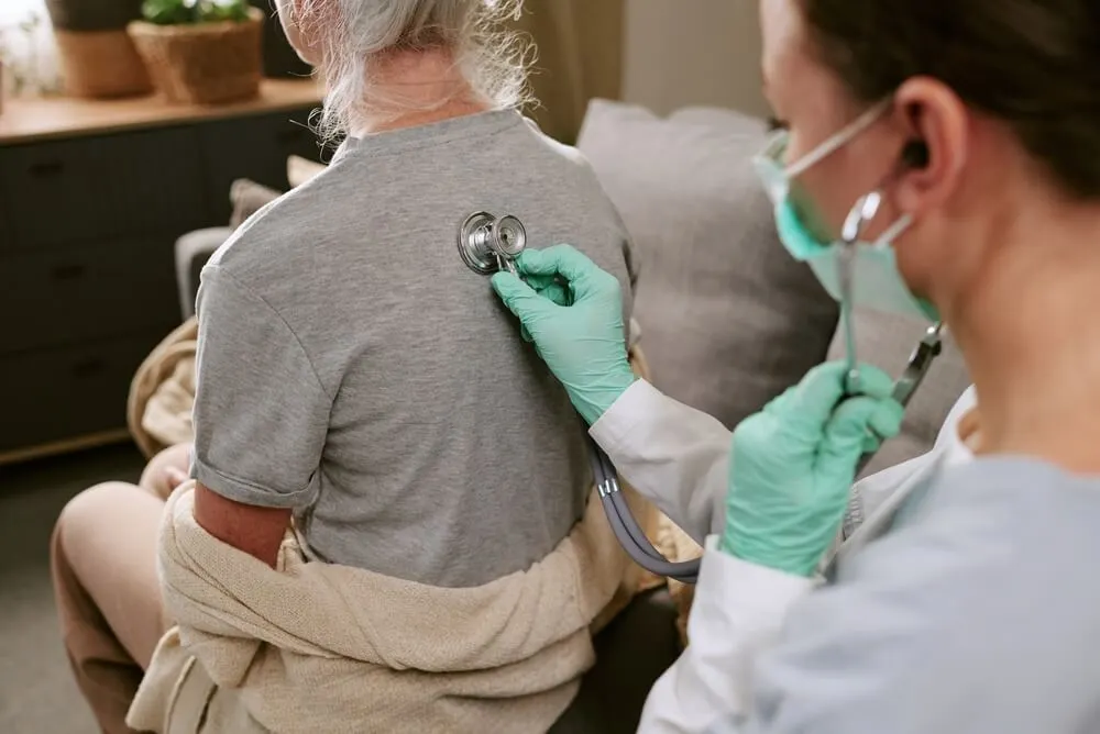Un médico utiliza el estetoscopio con un paciente