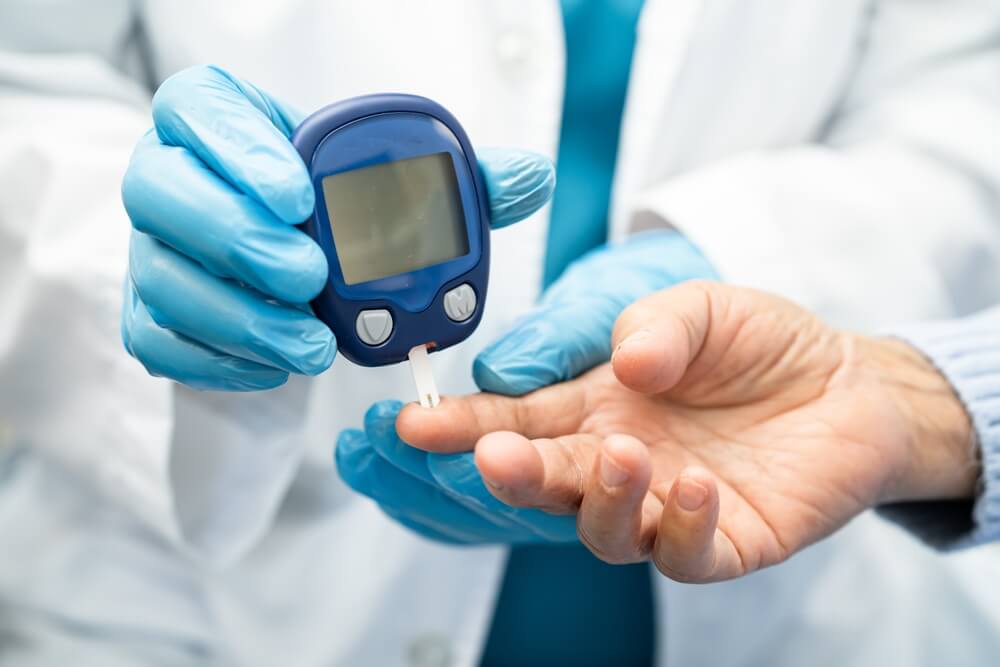 doctor uses blood lancet on patient's finger