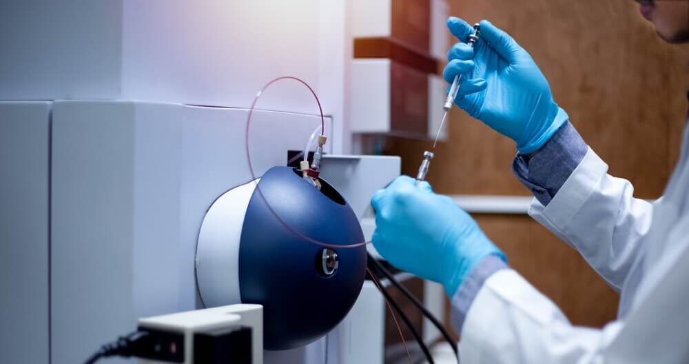 Scientist operates a mass spectrometer